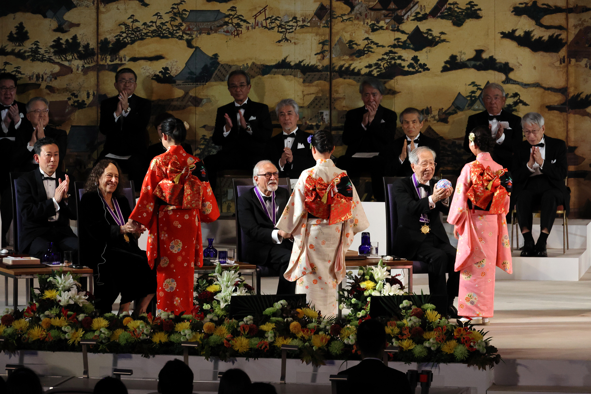 写真：記念品の手毬を受け取る受賞者たち